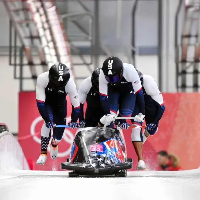 Athletes pushing bobsled